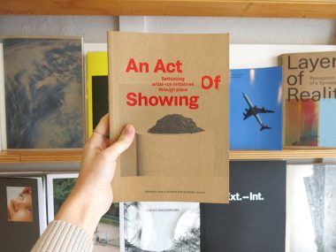 A photo of a hand holding up the Act of Showing book