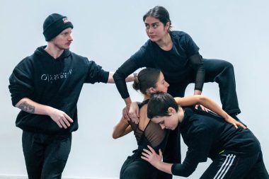 Jayden Hicks with students Alex, Ximena and Charlie at Transit Dance - they are all wearing black and in an intricate position and wrapping and bracing of limbs and bodies.