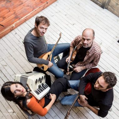 Four rebetiko musicians shot from above holding their instruments