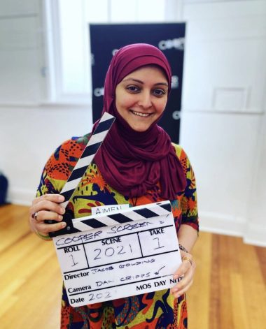 Aimen Jafri young woman wearing a headscarf and holding a film clapper board