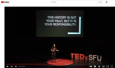 Nikki Sanchez on a TED stage with a slide reading 'This history is not your fault. But it is your responsibility.