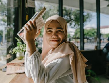 Young woma in a headscarf reading a book