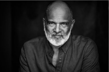 black and white shot of Tony Briggs wearing dark shirt against dark background