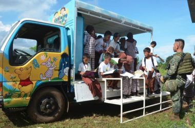 Children reading books from the ‘Sasakyang Aklatan’, which translates as 'Library on Wheels'