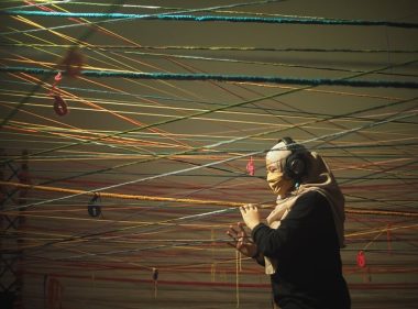 A member of the public navigates the maze of colourful ropes with touch while listening carefully to an audio track in the completed Move For?ward installation at the National Gallery of Singapore