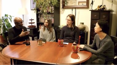 Four artists having a discussion in a cozy living room space, sitting around a wooden table with coffee mugs. Video Credit: CPAMO's Art in Conversation: Interview with Wayne Dunkley, Akshata Naik and Lisa Frost from CPAMO, 2019